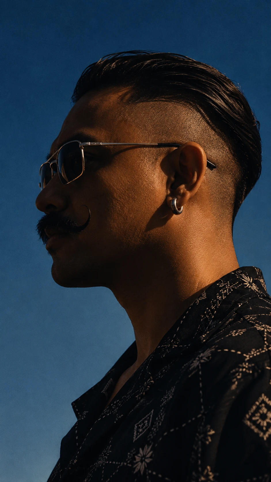 Andreas Jason Villamor in profile against a deep blue sky